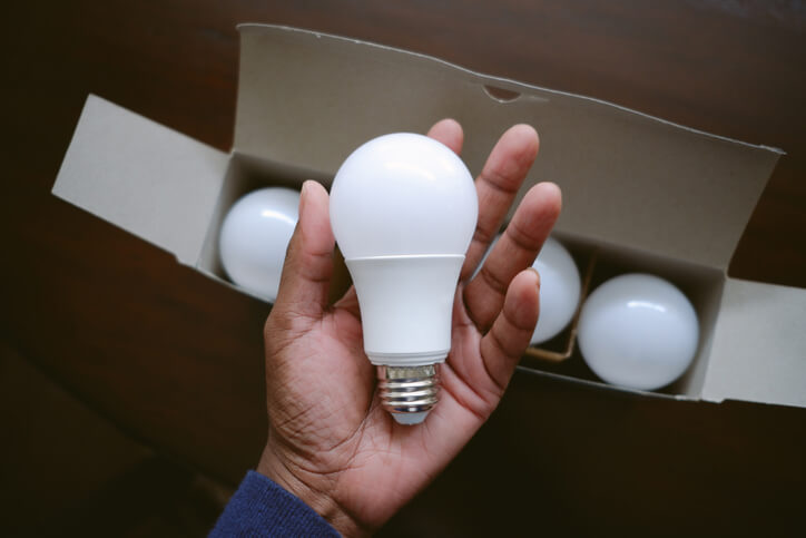 eco-friendly lightbulbs in hand to help cool the home